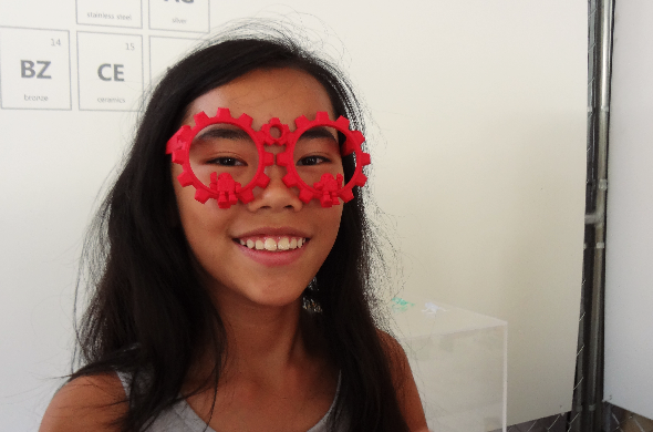 Maker Faire New York 2014: tween girl wearing 3D printed red polyamide glasses at our booth