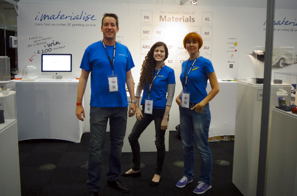 Picture from the 2014 London 3D Printshow featuring Rebecca Roxy Maas, Darya Kireyeva, and Sam Vandormael standing together in front of the i.materialise booth.