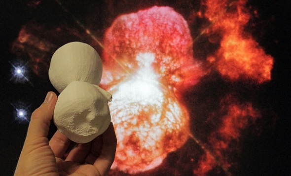 A 3D printed model of the Homunculus Nebula is compared with a Hubble image of the object (photo credit: NASA)