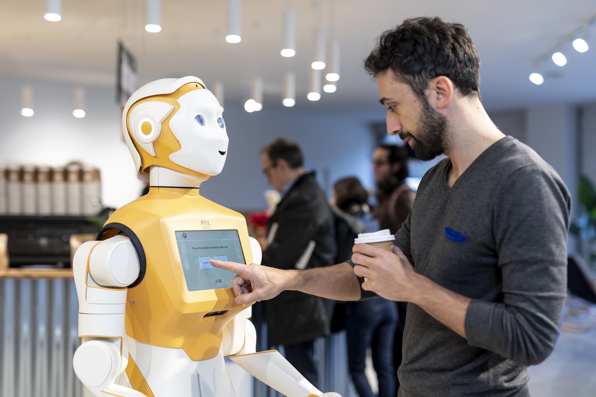 Man interacting with a social robot ARI through a touch screen