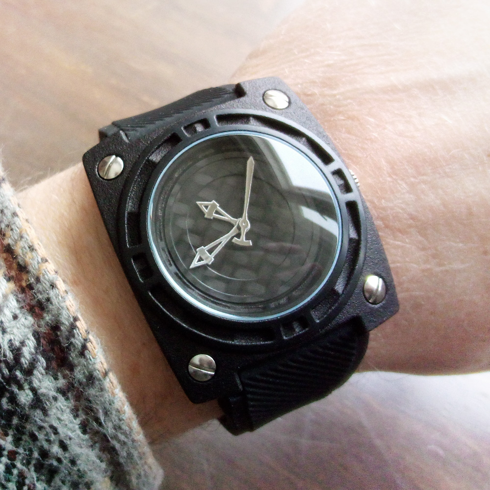 Person wearing a black watch with parts 3D printed in plastic 