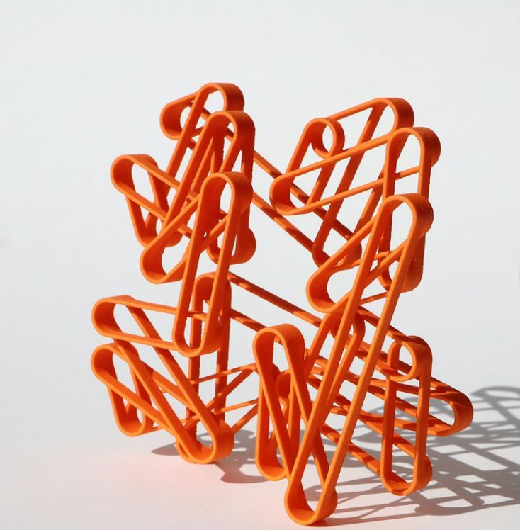 An orange geometric object designed by Koenraad Van Daele